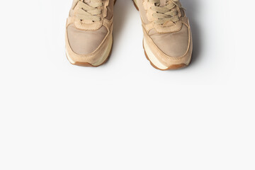 Women's beige sneakers with laces on a light background. Flat lay, top view