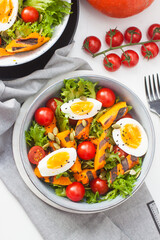 Vegetable salad with grilled carrot, cherry tomatoes, pumpkin, lettuce, boiled eggs and sesame seeds.
