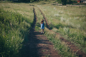 child against the background of wild nature. Russian mountains, plains, fields. the girl in the tall grass and looks into the distance