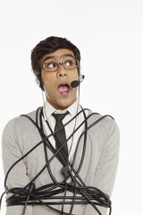 Man with headset wrapped in a tangled cable