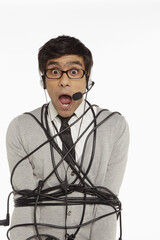 Man with headset wrapped in a tangled cable