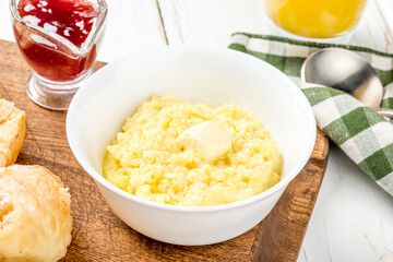 Breakfast millet porridge with butter and jam in a white plate
