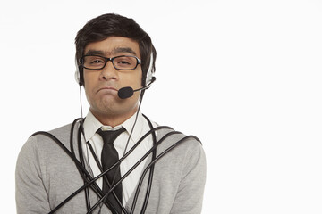 Man with headset wrapped in a tangled cable