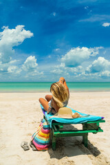 Woman on a sun lounger at the white sand tropical beach