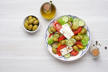 Greek salad with feta cheese, tomatoes, cucumbers, lettuce, olives and spices. Traditional greek...