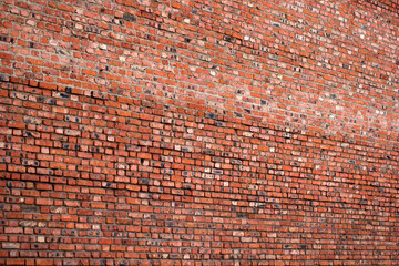 red brown brick wall with a shallow depth of field at an angle to the plane. Selective focus. grunge brick wall texture perspective view
