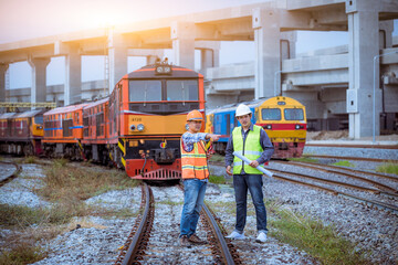 Portrait engineer under inspection and checking construction process railway switch and checking work on railroad station .Engineer wearing safety uniform and safety helmet in work.