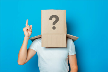 Young man in a white T-shirt with a cardboard box on his head ma