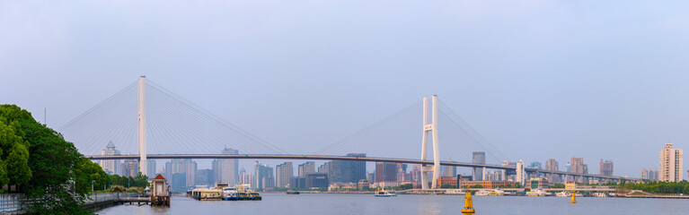Panorama view of Nanpu Bridge across the Huangpu River, in Shanghai, China, on a cloudy day.