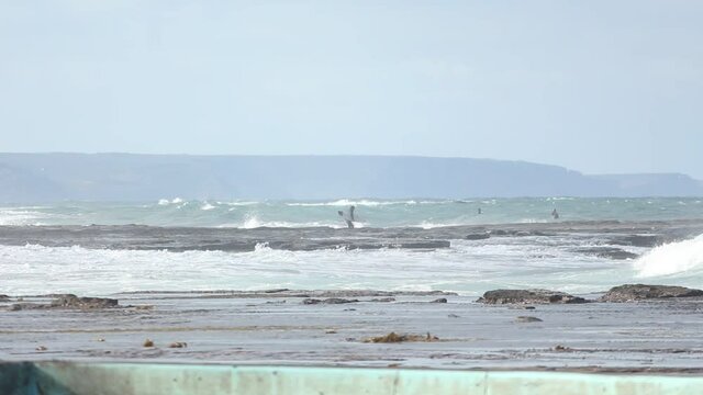  a surfer running towards the big waves to surf