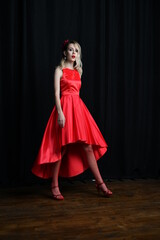 young and beautiful girl tries on her first evening red dress