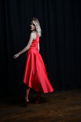 young and beautiful girl tries on her first evening red dress