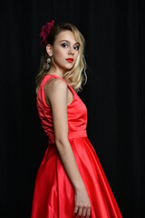 young and beautiful girl tries on her first evening red dress