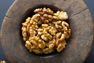 Walnuts in antique, wooden mortar.