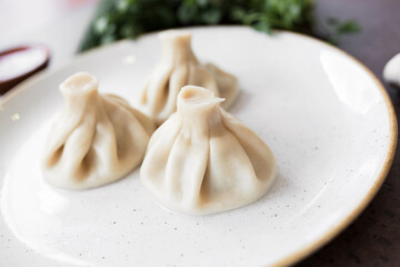 Georgian Khinkali on a white plate. Closeup. view from above. National cuisine