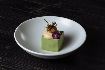 Panacotta dessert with green color with pickled strawberries - 361940326