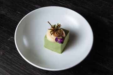Panacotta dessert with green color with pickled strawberries - 361940329