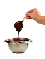 Hand dipping vanilla ice cream in heart shape on wooden stick in hot liquid dark chocolate