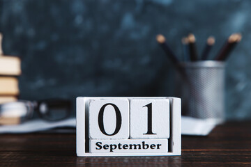 Books, calendar, notebooks, pencils, glasses and a cup of coffee, against the background of a chalkboard. Concept for knowledge day. Copy space.