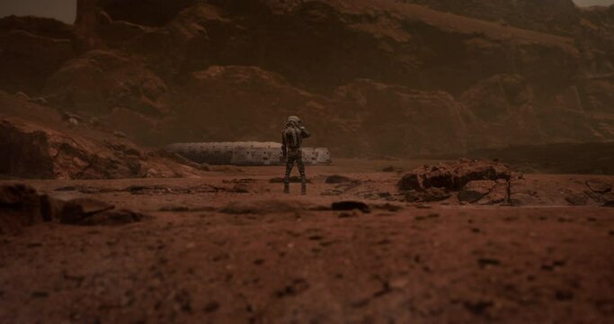 Back view of astronaut looking on a space habitat colony from a distance. Mars colonization concept