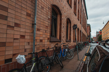 Bicycles near facade of building on walkway on urban street in Copenhagen, Denmark