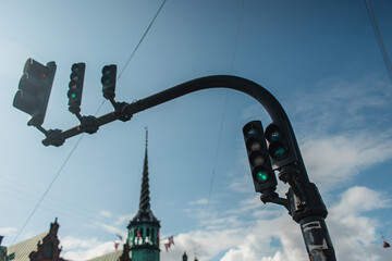 Obraz premium Low angle view of traffic lights with cloudy sky at background on urban street in Copenhagen, Denmark