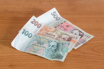 CZK Czech koruna banknotes on wooden table.