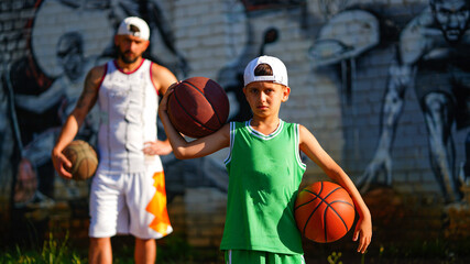 Basketball family father with beard and son in jersey with balls