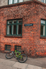Fototapeta na wymiar Bicycle on walkway near brick facade of building in Copenhagen, Denmark
