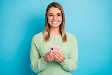 Fototapeta premium Close-up portrait of her she nice-looking attractive lovely pretty cheerful cheery girl using digital device spending free time isolated over bright vivid shine vibrant blue color background