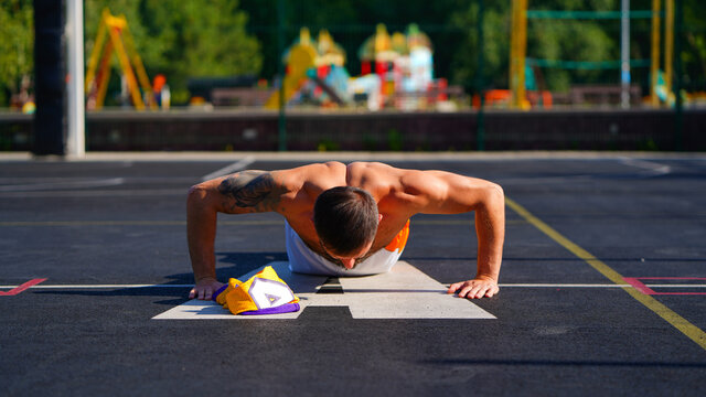 Basketball player with beard doing push-ups on floor