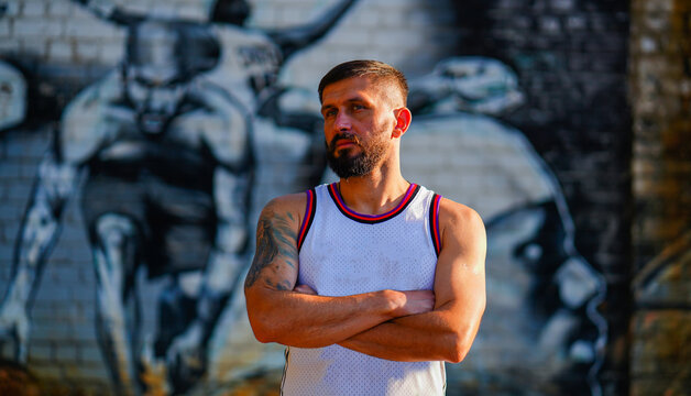 A Basketball Player With Beard In Jersey With Folded Arms