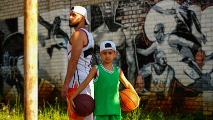 Fototapeta na wymiar Basketball family father with beard and son in jersey with balls