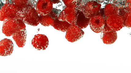 Raspberries falling into water