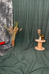 Design of interior photo studio with straw in vase and green background. Minimalistic interior