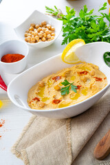 hummus paste with lemon and chilli on white background