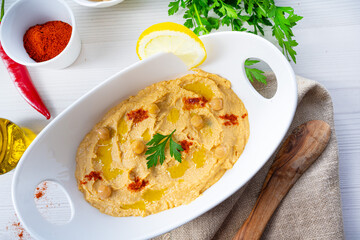 hummus paste with lemon and chilli on white background