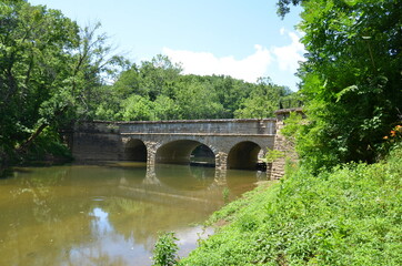 Fototapeta na wymiar aqueduct bridge and river water and plants