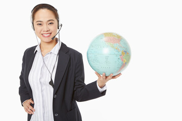 Fototapeta premium Businesswoman with headset holding a globe