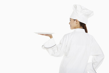 Female chef holding up a tray