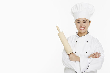 Female chef holding up a rolling pin
