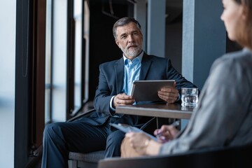 Image of mature businessman interviewing female.