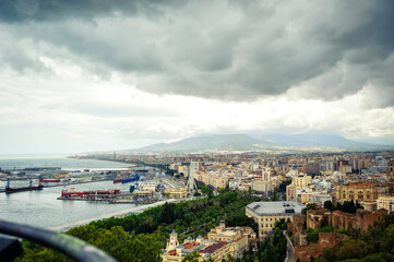 Fototapeta premium Aerial panoramic view of cityscape and harbour of Spanish city of Malaga, Costa del Sol, Spain, in spring cloudy day. Travel tourism destination