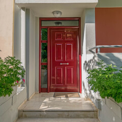elegant family house entrance dark red door by the sidewalk, Athens Greece