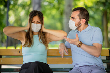 New normal concept after the pandemic an arguing couple view, man is dictating, woman close ears...