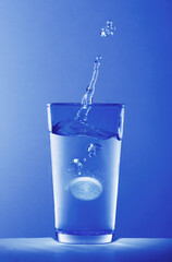 Soluble pill dropping into a glass of water