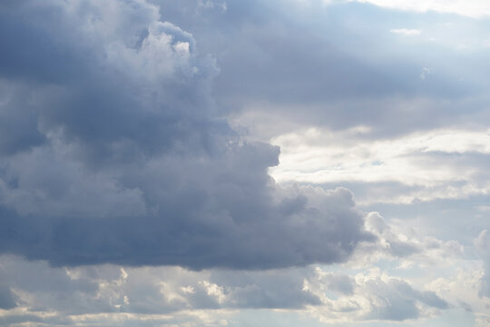 Blue sky on a sunny day with gray white clouds. Nature background.