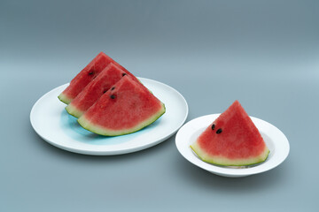 Several pieces of watermelon are placed in a white porcelain dish. Watermelon is placed in a white dish