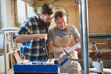 Two carpenters check a checklist