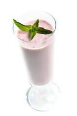 Blueberry milk shake in tall glass on white background garnished with mint leaves